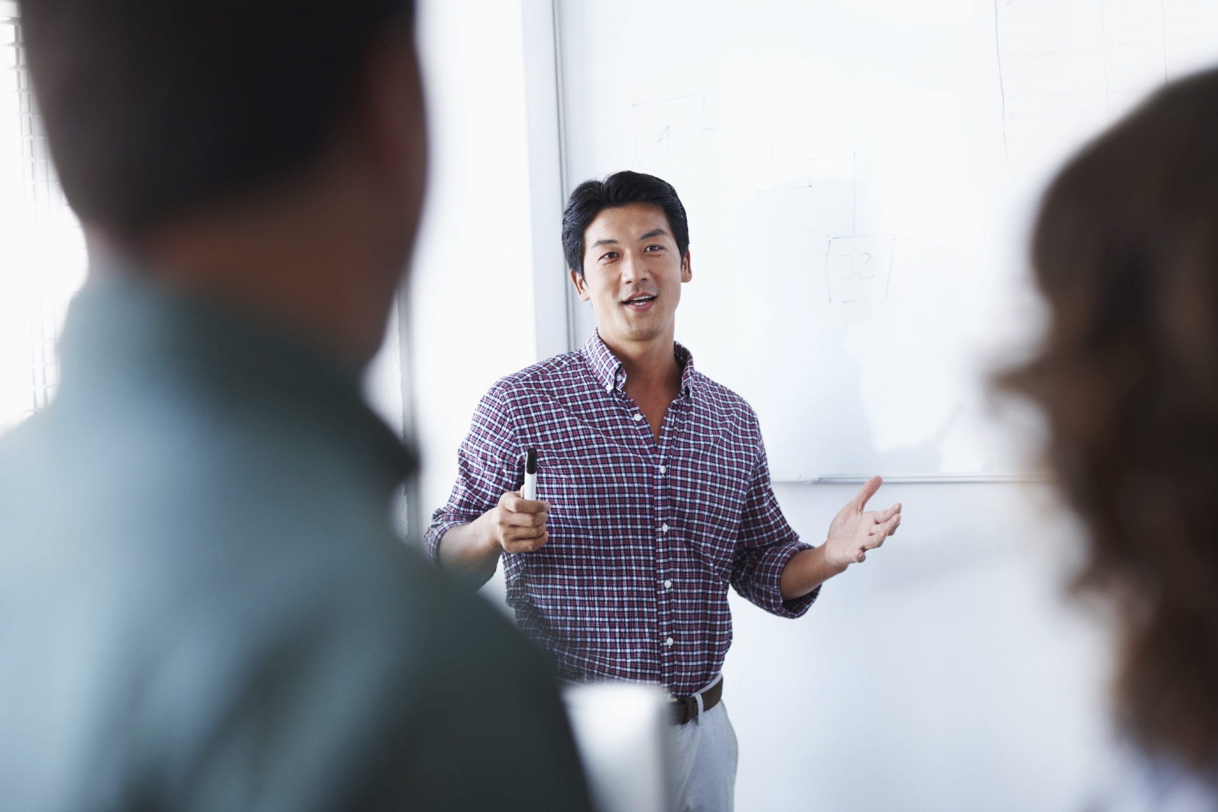 An asian associate giving a presentation using a whiteboard